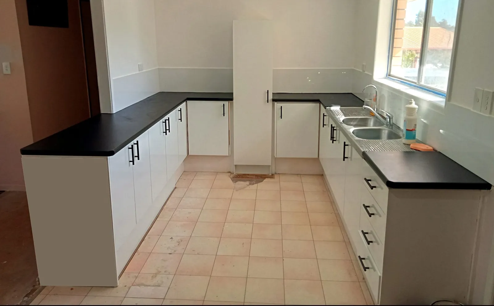 Completed kitchen renovation with white cabinetry and charcoal benchtops - Gold Coast
